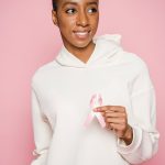 A cancer survivor holding a pink ribbon