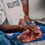 A volunteer holding hands with a patient